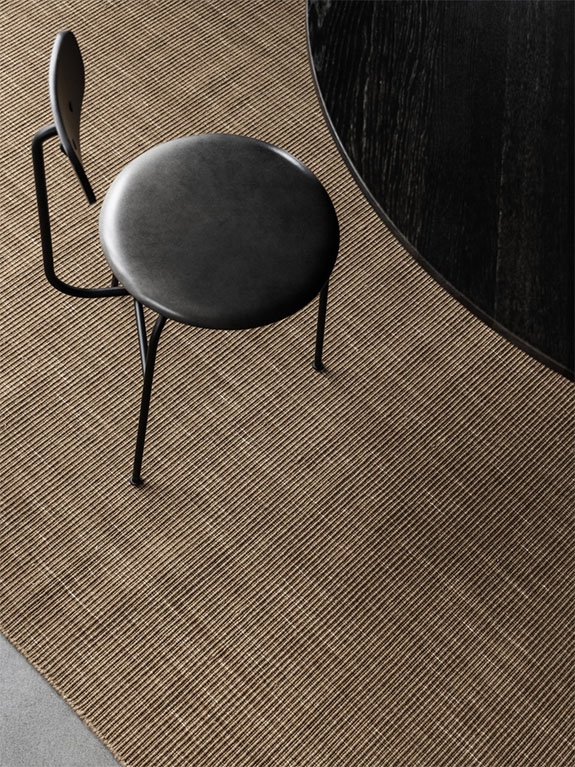 Handwoven greige wool rug under dining table