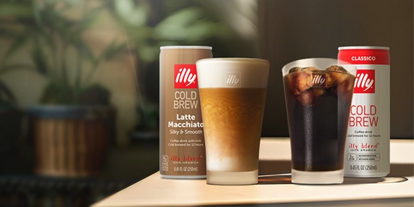 Can of illy coffee on a counter with a woman carrying an illy travel mug