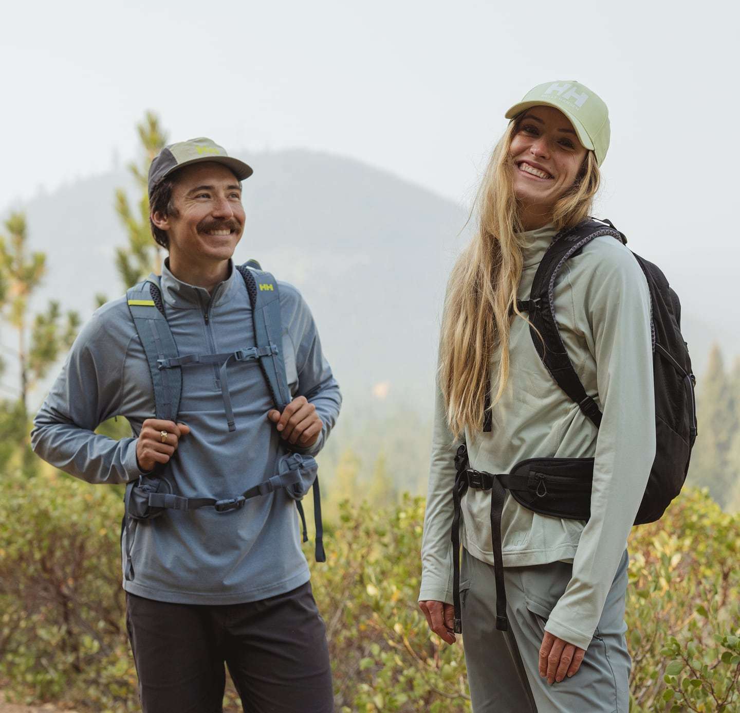 Man and woman hiking in Helly Hansen midlayers