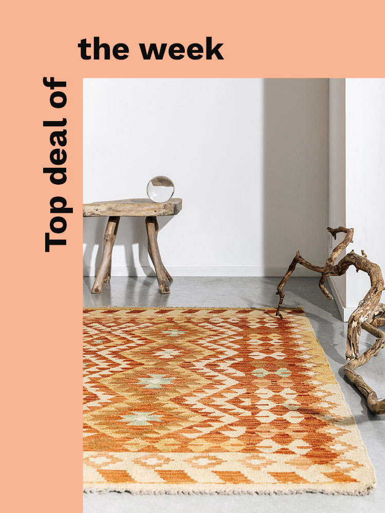 Orange coloured kelim rug by a window