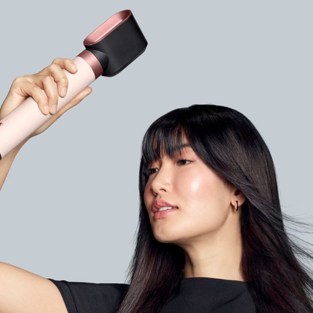 Lo styler asciugacapelli Dyson Airwrap Co-anda2x con l’accessorio per un’asciugatura rapida 2x usato da una modella per asciugare i suoi capelli lunghi scuri.