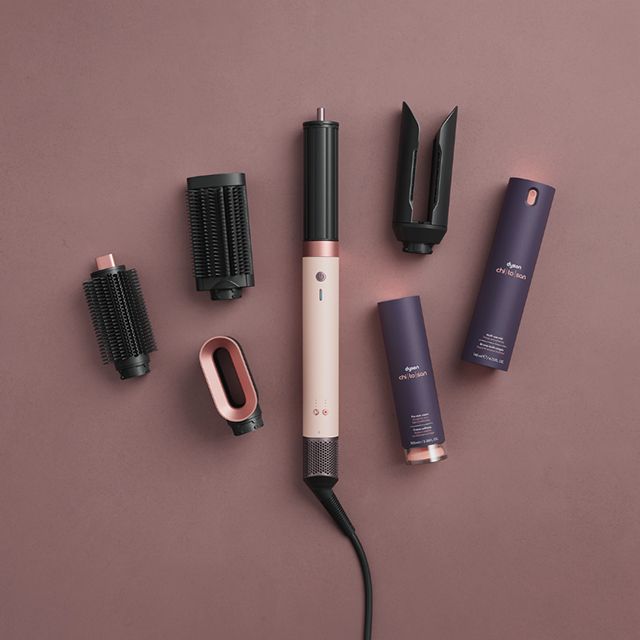 The Dyson Airwrap Co-anda2x multi-styler and dryer surrounded by attachments and Dyson Chitosan styling formulations.