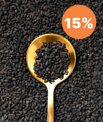 alt="Cucchiaio dorato pieno di semi di cumino nero su uno sfondo di semi neri sparsi, sconto del 15 %"