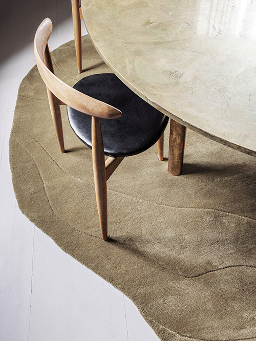 Irregular beige rug under a dining table