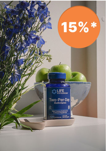 alt="Un flacone di multivitaminico Two-Per-Day di Life Extension su un tavolo con fiori blu e mele verdi sullo sfondo, con un adesivo sconto del 15%"