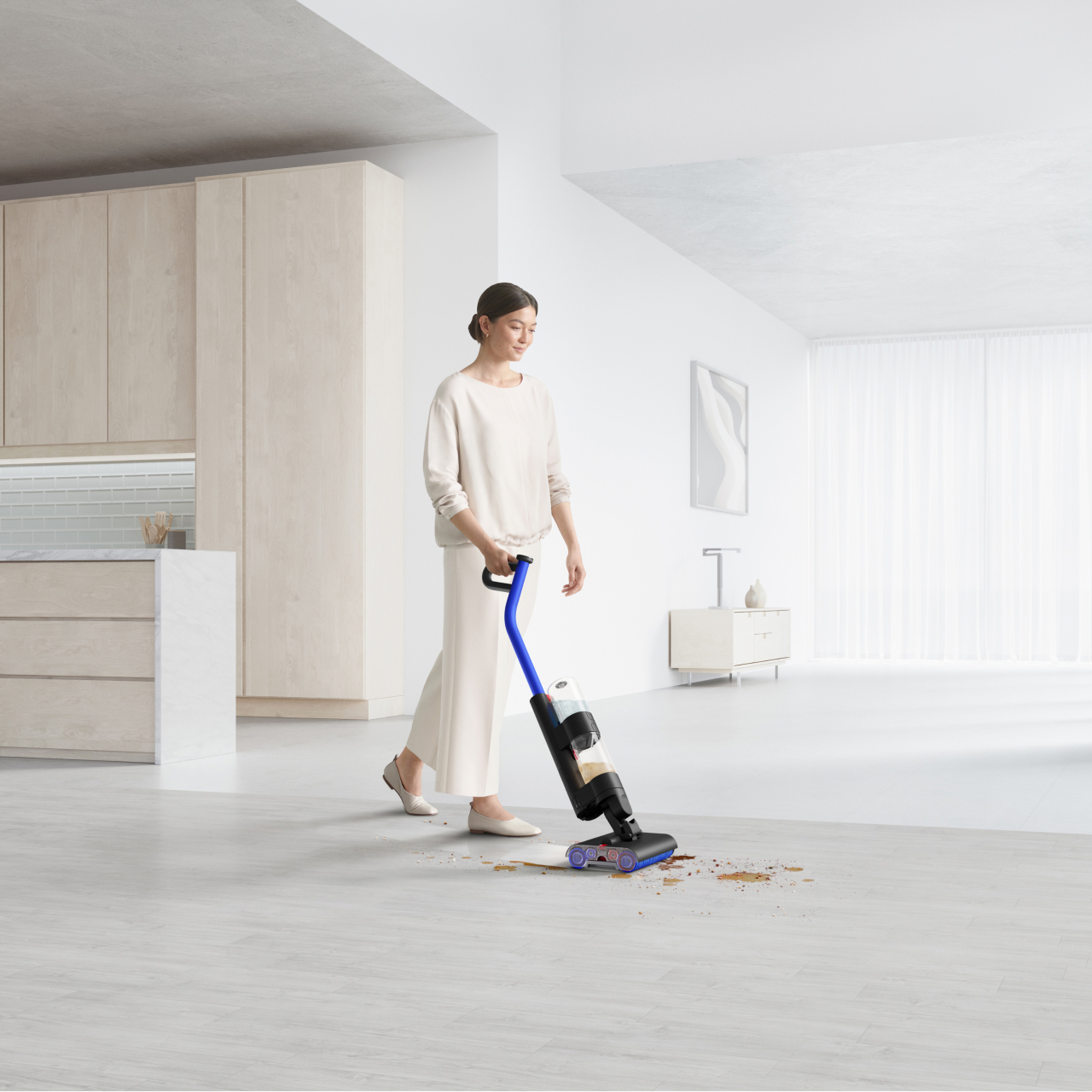 A woman cleaning a large open plan living area with the Dyson WashG1 wet cleaner.