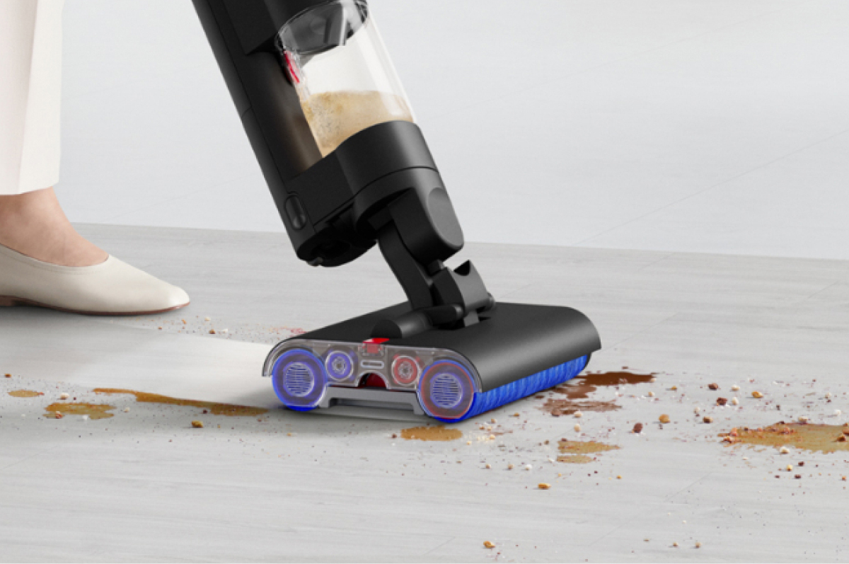 A close-up of cleaner head removing dry dirt and wet mess on a hard floor.