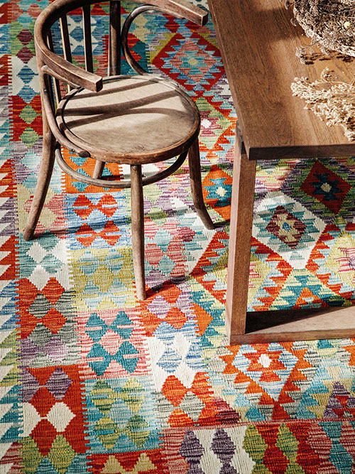 Colourful kelim rug under dining table