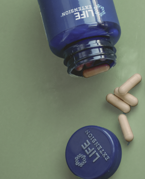 alt="Primo piano di un flacone di integratore Life Extension sdraiato su uno sfondo verde con capsule beige sparse."