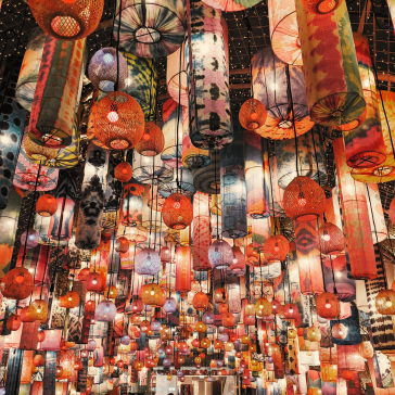 Vibrant, colourful lanterns hang close together, creating an eye-catching pattern.