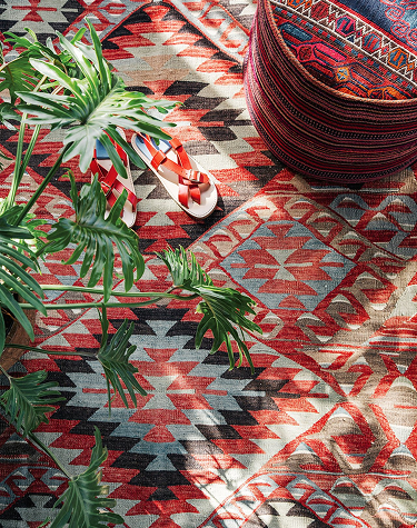 Close up on a red and multi colored kilim rug