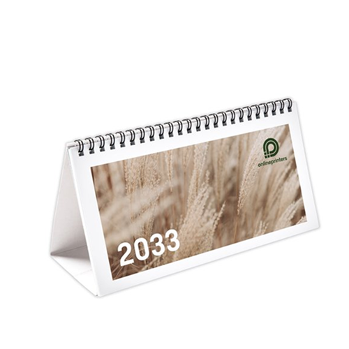 Un calendario da tavolo con un anello a spirale che riporta l'anno “2033” scritto in bianco su uno sfondo di erba secca.