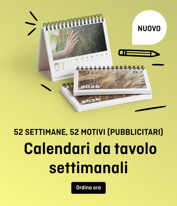 Un calendario da tavolo con rilegatura a spirale mostra il mese di luglio 2025. È visibile il testo “52 SETTIMANE, 52 MOTIVI (PUBBLICITARI) Calendario da tavolo settimanale”. Sullo sfondo sono visibili una penna e la parola “NUOVO”.