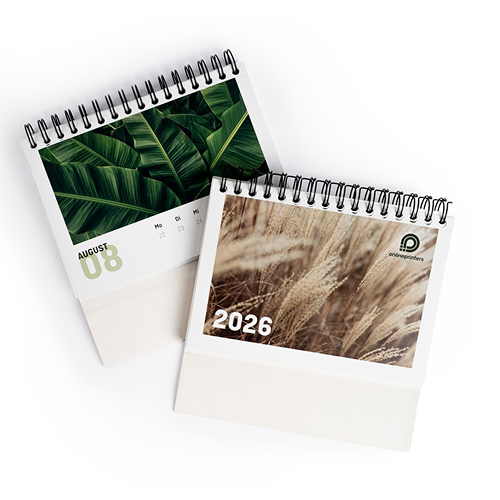 Due calendari da tavolo con rilegatura a spirale. A sinistra agosto 2026 con foglie verdi, a destra 2026 con un'immagine di cereali.