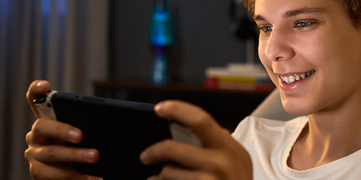Primo piano di un giovane giocatore che gioca su una console Nintendo Switch™