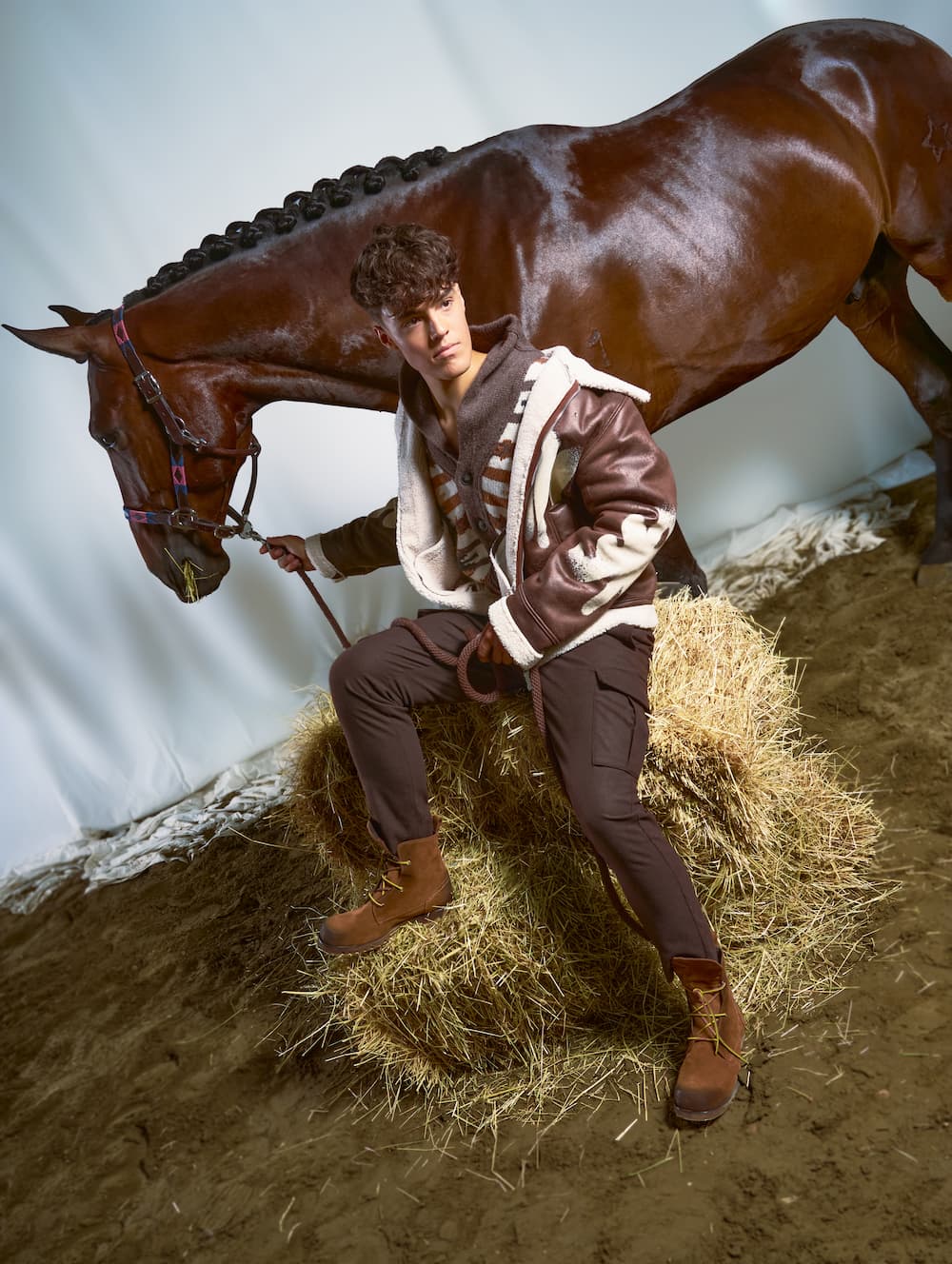 Immagine di un uomo accanto al suo cavallo che indossa scarpe della nuova collezione.