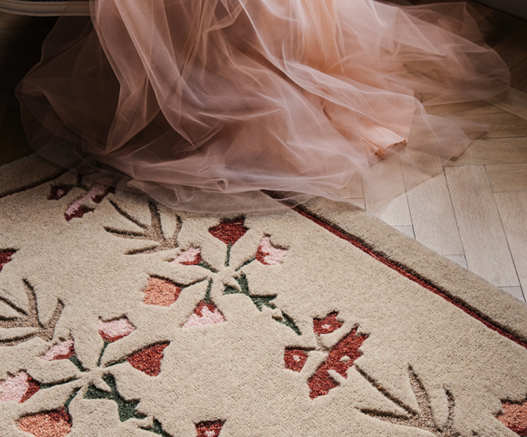 Close up on a beige rug with pink flowers
