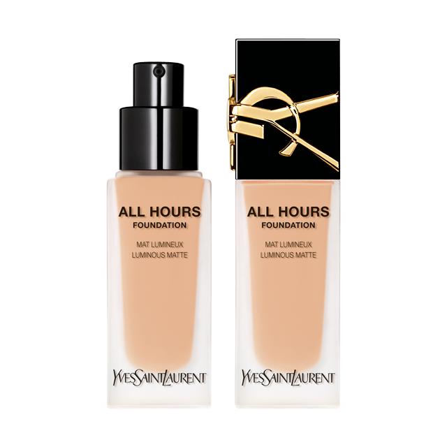 Due flaconi di fondotinta con dosatore, probabilmente "All Hours" di YSL, che mostrano tonalità di pelle calde e naturali. Sono posizionati uno accanto all'altro su una superficie bianca.