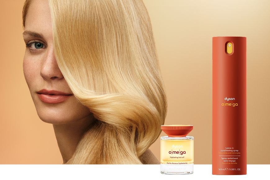 Model with nourished hair behind the Dyson Omega nourishing range.