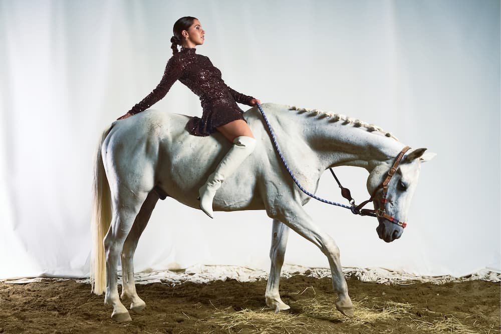 Immagine di un uomo accanto al suo cavallo che indossa scarpe della nuova collezione.