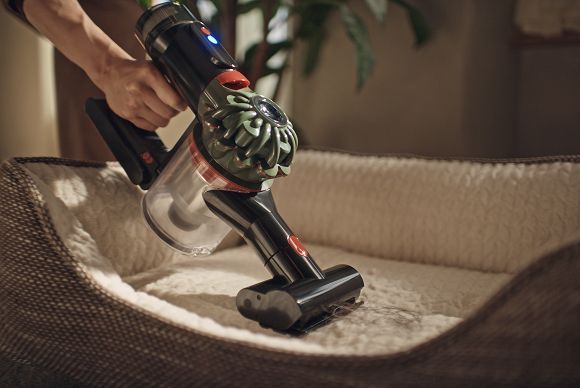 L’aspirapolvere Dyson V8 Cyclone viene utilizzato con la mini turbo spazzola per pulire la cuccia di un animale domestico.