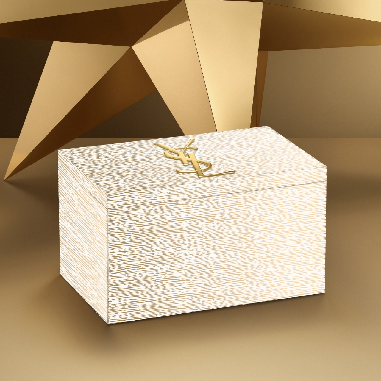 Calendario dell'Avvento di lusso Yves Saint Laurent (YSL), una scatola rettangolare con una superficie bianca testurizzata e un prominente logo YSL dorato sulla parte superiore, su uno sfondo geometrico dorato