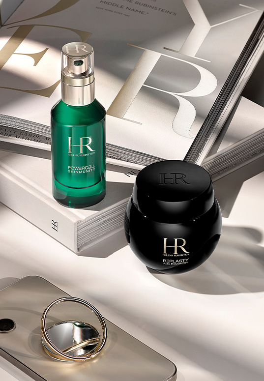 Il duo siero Powercell e Re-Plasty Age Recovery Night appoggiato su libri dedicati al marchio.