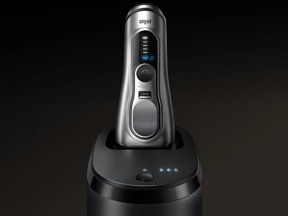Rasoio elettrico Braun con stazione di pulizia e ricarica automatica, display a LED e design moderno in metallo.