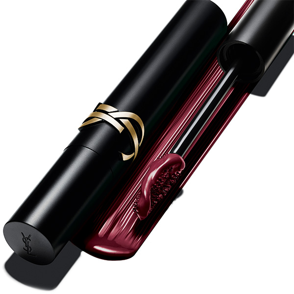 Un primo piano di un mascara Yves Saint Laurent aperto con un tubetto nero e il logo YSL dorato, che rivela una ricca formula bordeaux e uno scovolino appositamente progettato.