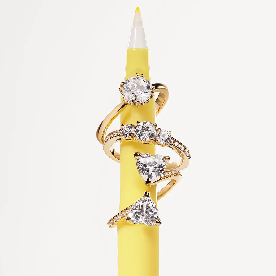 Un pennarello giallo da cui pendono tre anelli Swarovski in tonalità oro