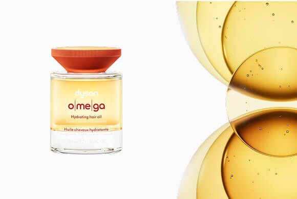 Olio idratante per capelli Dyson Omega accanto a una miscela di oli.