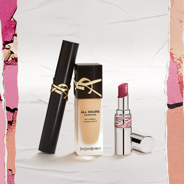 Una selezione curata di essenziali make-up YSL Beauté, tra cui il fondotinta All Hours, un mascara elegante e un rossetto vibrante, è artisticamente disposta su uno sfondo bianco tenue con delicati e colorati effetti di carta strappata. Questi prodotti promettono una carnagione radiosa e impeccabile.