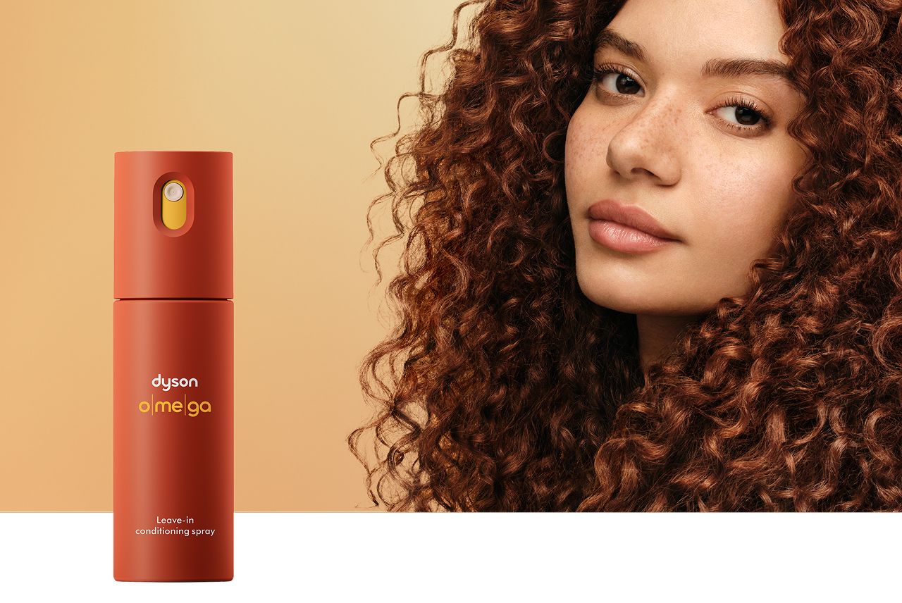 Modella con capelli ben nutriti dietro il balsamo spray senza risciacquo Dyson Omega.