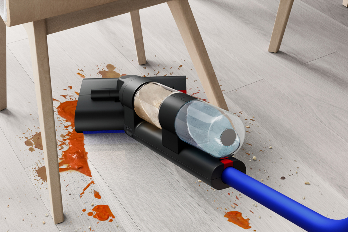 A close-up of the WashG1 reaching low to reach food spills under a kitchen table.
