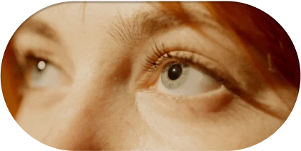 alt="Primo piano degli occhi azzurri di una donna rivolti verso l'alto, dolcemente illuminati da una calda luce naturale, che simboleggia una visione chiara e sana.»