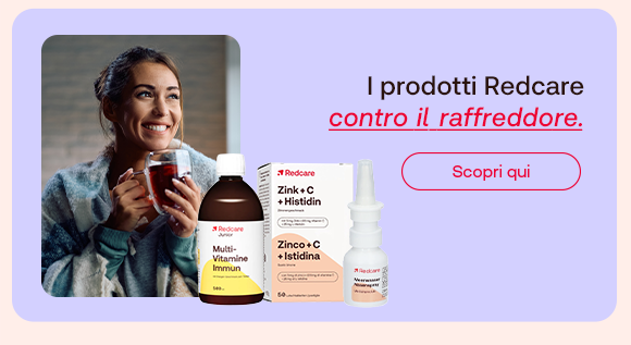 „Donna sorride avvolta in una coperta mentre beve una tisana calda. Accanto, prodotti Redcare Multi-Vitamine Immun, Zink + C + Histidin e spray nasale. Testo: I prodotti Redcare contro il raffreddore. Pulsante rosso: Scopri qui.“