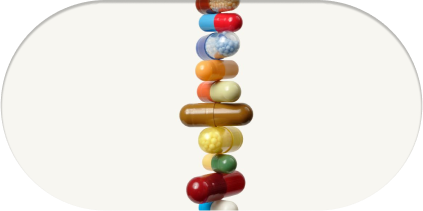 alt="Linea verticale di capsule e pillole colorate assortite disposte in una pila bilanciata su uno sfondo bianco, che simboleggia una varietà di integratori alimentari.»