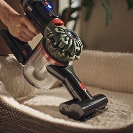 L’aspirapolvere Dyson Cyclone DS20 viene utilizzato con la mini turbo spazzola per pulire la cuccia di un animale domestico.