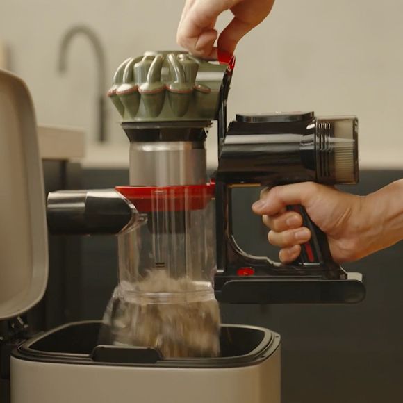 L’aspirapolvere senza filo Dyson Cyclone DS20 viene svuotato in un contenitore per i rifiuti domestici.