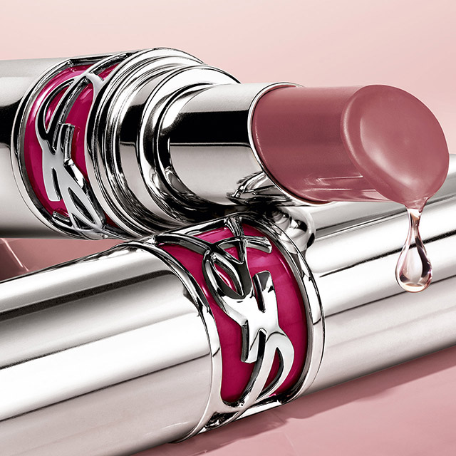 Un rossetto YSL rosa-nude aperto con una goccia che cola.