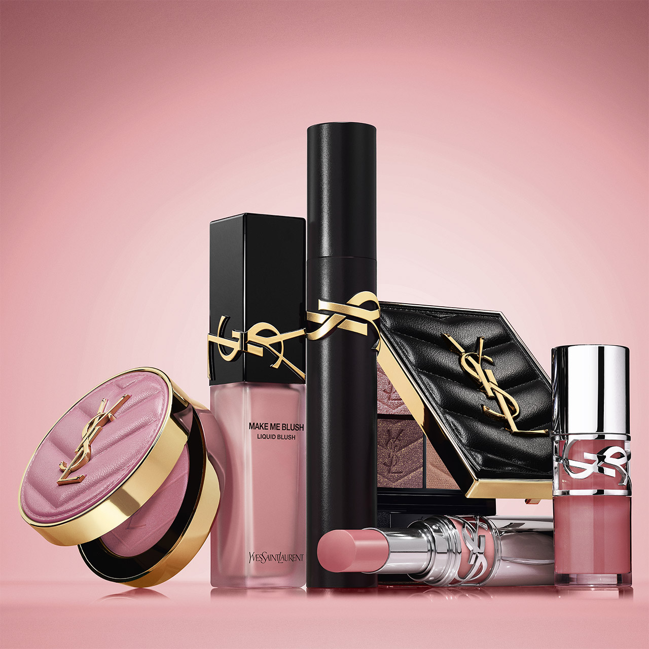 Una collezione di prodotti make-up YSL, tra cui blush, mascara e rossetto, su sfondo rosa.
