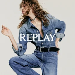 Completo in denim di un azzurro chiaro con corpetto aderente, gambe larghe e maniche lunghe. Presenta una chiusura con bottoni sul davanti e un accentato cinturino nero.