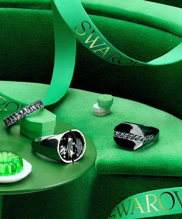Gioielli Swarovski e confezione regalo verde posati su un tavolo verde su sfondo verde Gioielli Swarovski e confezione regalo verde posati su un tavolo verde su sfondo verde