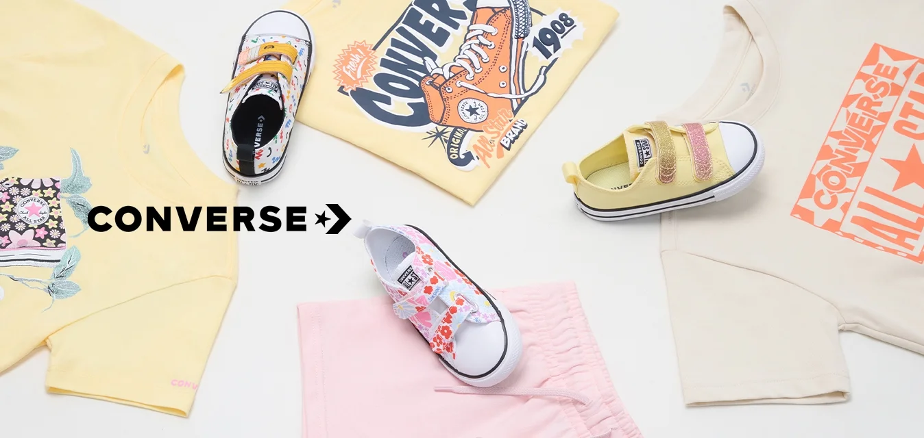 Abbigliamento e calzature Converse: t-shirt gialla a maniche corte con design floreale, t-shirt beige con grafica arancione, pantaloni corti rosa, sneakers con motivo colorato.