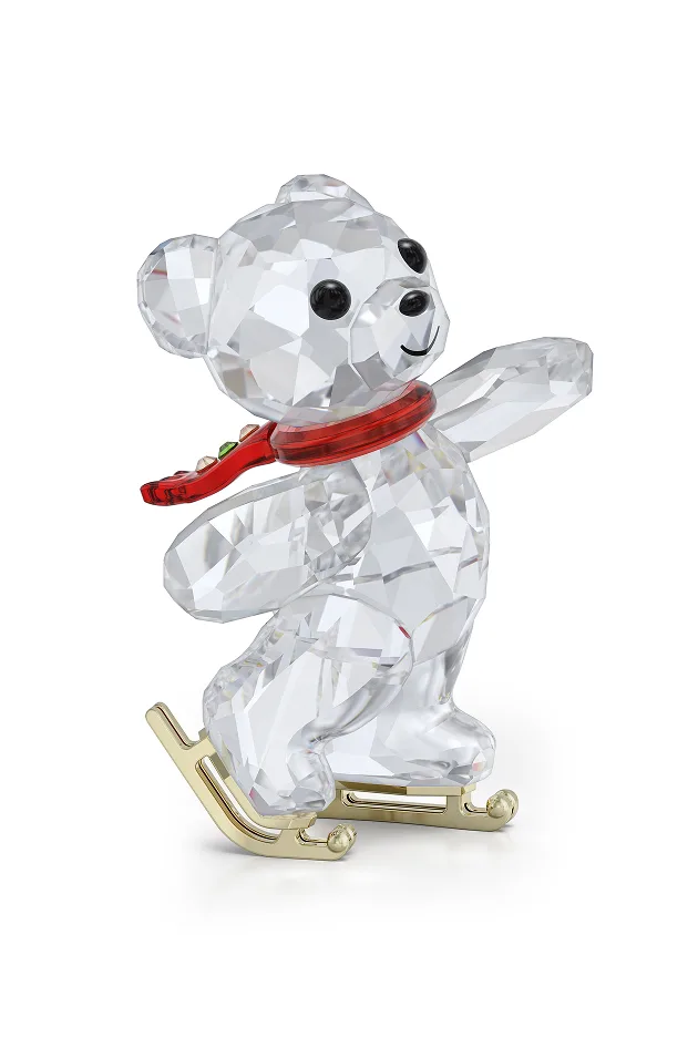 Orsetto Kris con sciarpa rossa che pattina sul ghiaccio