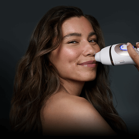 Immagine con donna che sorride mentre utilizza la luce pulsata con la testina di precisione sui baffetti