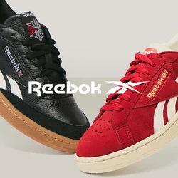 Sneaker Reebok in pelle nera e suede rossa mostrati affiancati, una scarpa rossa mostra la suola con un motivo testurizzato.