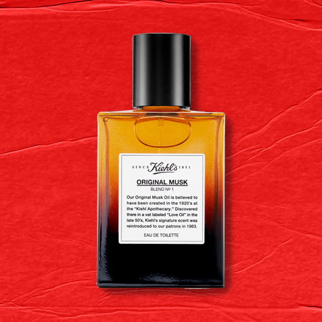 Flacone ambrato e nero di Kiehl’s Original Musk Eau de Toilette con tappo nero e etichetta bianca, su sfondo rosso.