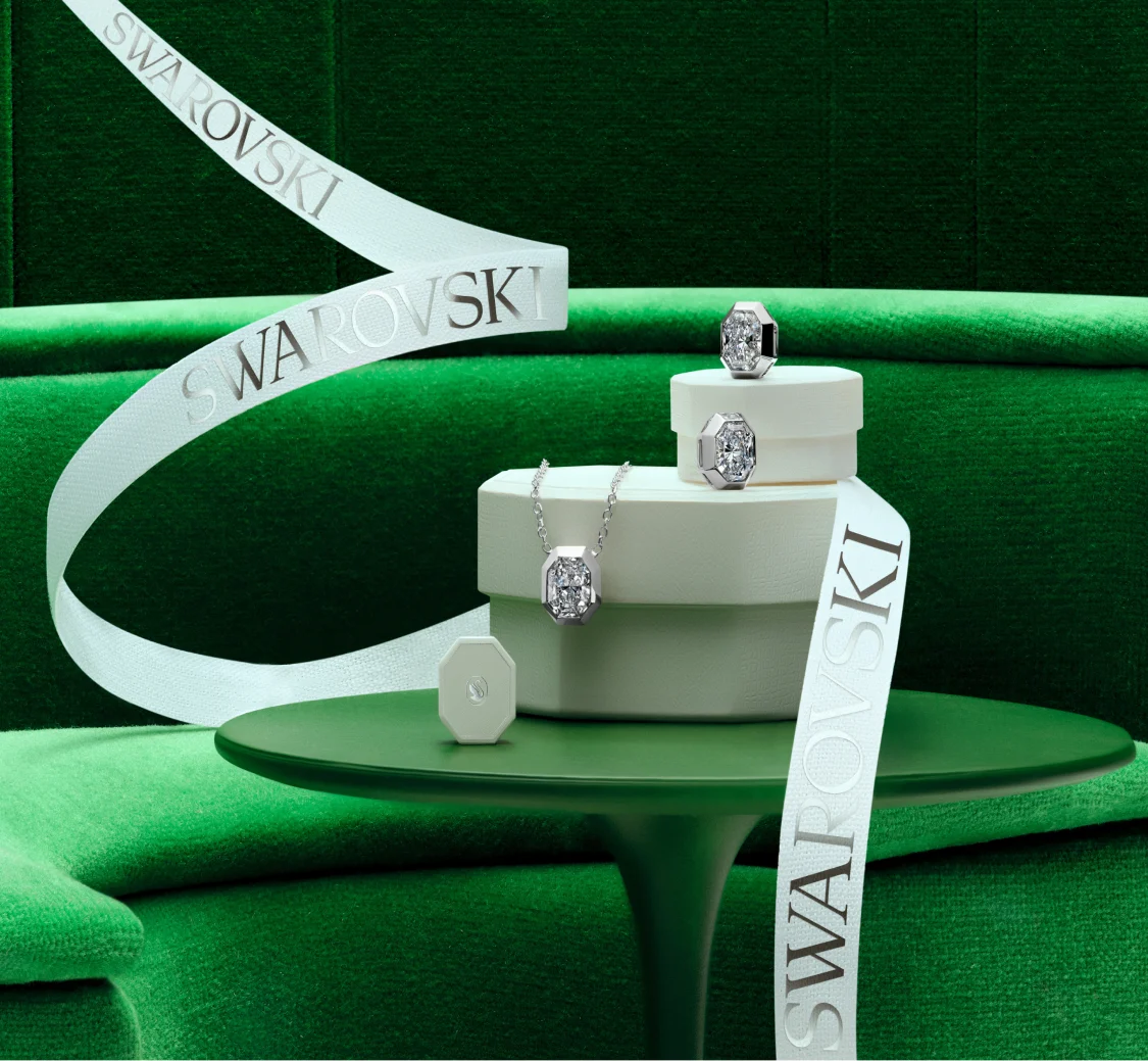 Gioielli Swarovski Created Diamonds e confezioni regalo bianche su sfondo verde