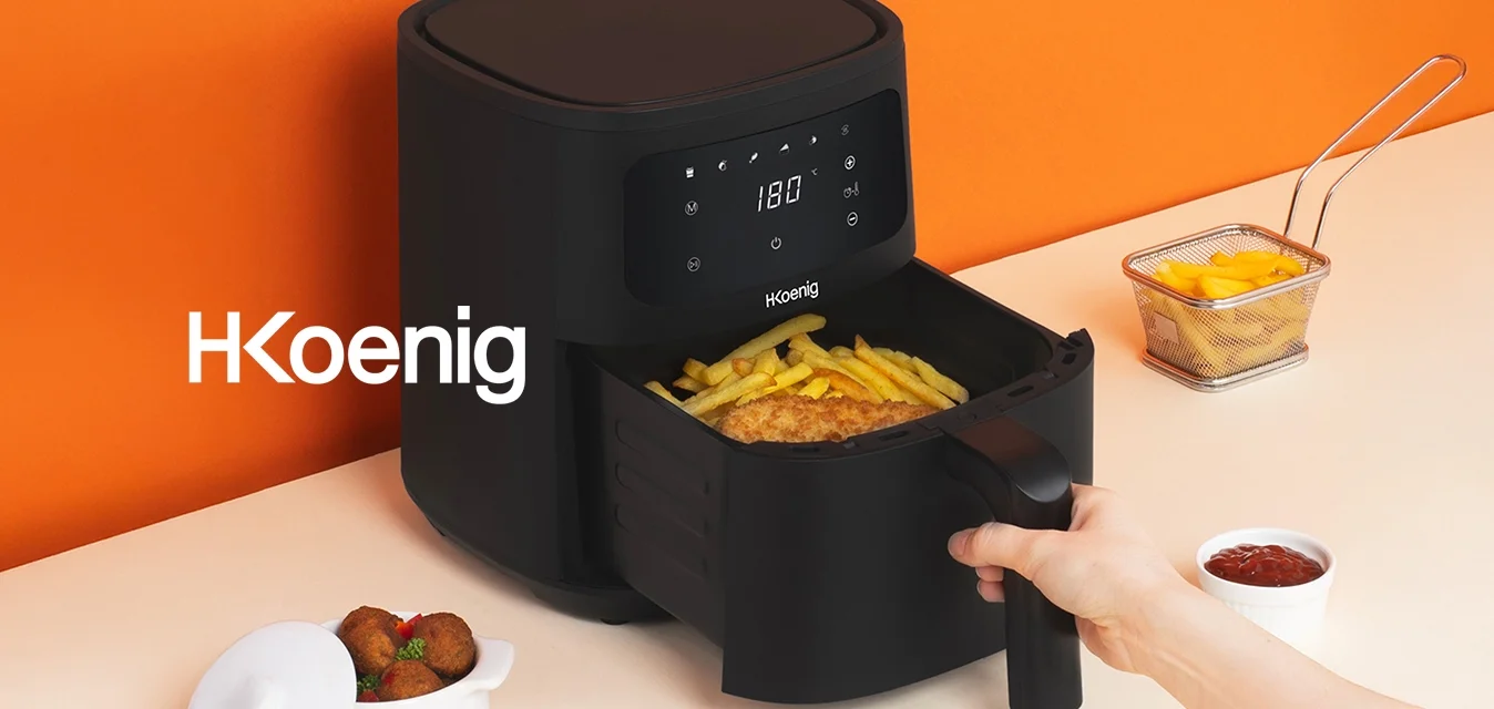 Uomo che estrae un cestello con patatine fritte e cibo impanato da una friggitrice ad aria digitale nera su un piano di lavoro beige con un muro arancione.